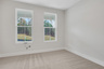 secondary bedroom on the main level with carpet and windows
