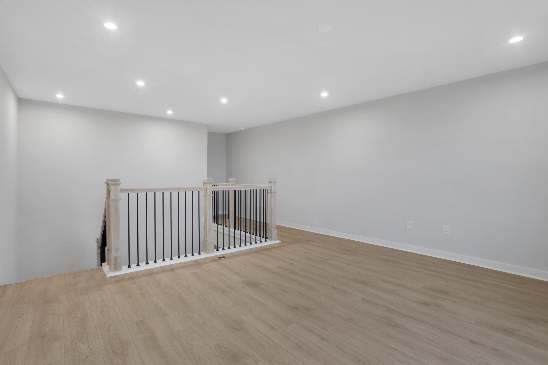 loft with hard-surface flooring and open rail staircase