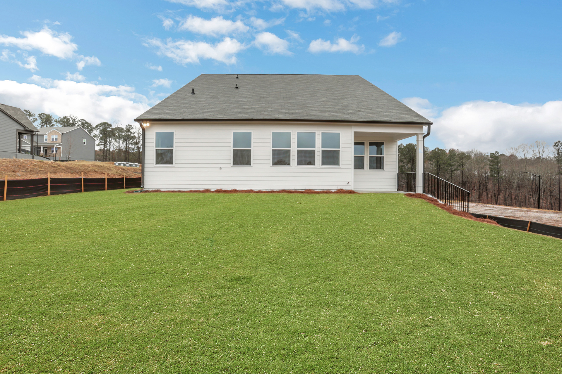back of home with covered patio and sizable backyard