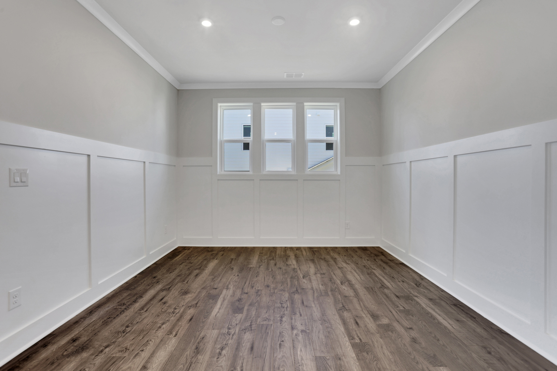 dining room with hard-surface flooring and wainscoting walls