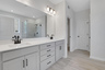 primary bathroom with dual vanity and gray cabinets
