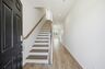 entryway with oak tread stairs with iron railing and wood floors