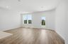 great room with wood floors, white walls, and large windows