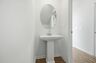 secondary bathroom powder room with standing sink and oval window