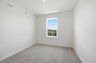 secondary bedroom with carpet, large windows, and double door closet