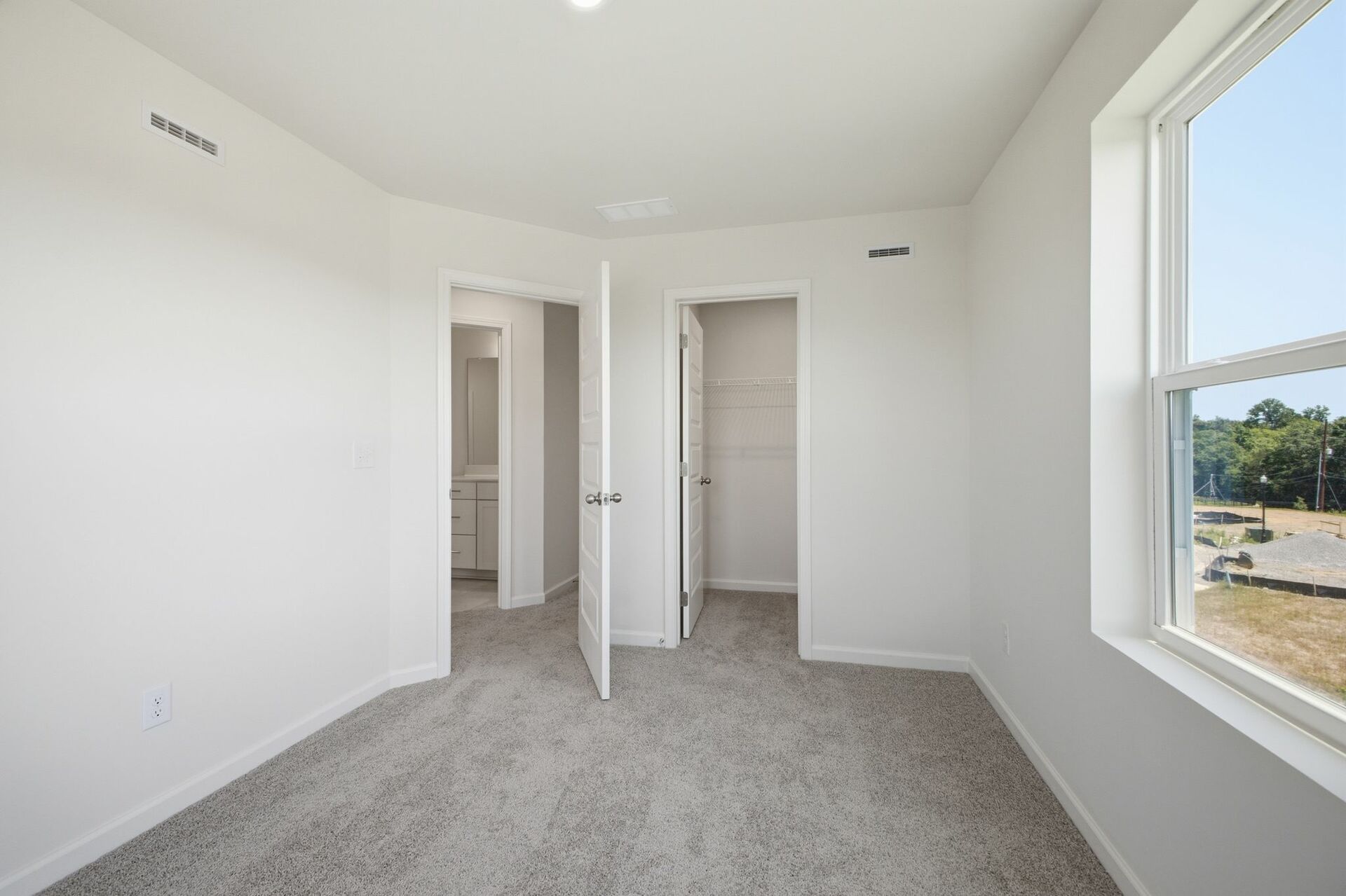 secondary bedroom with carpet, large windows, and double door closet