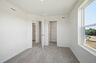 secondary bedroom with carpet, large windows, and double door closet