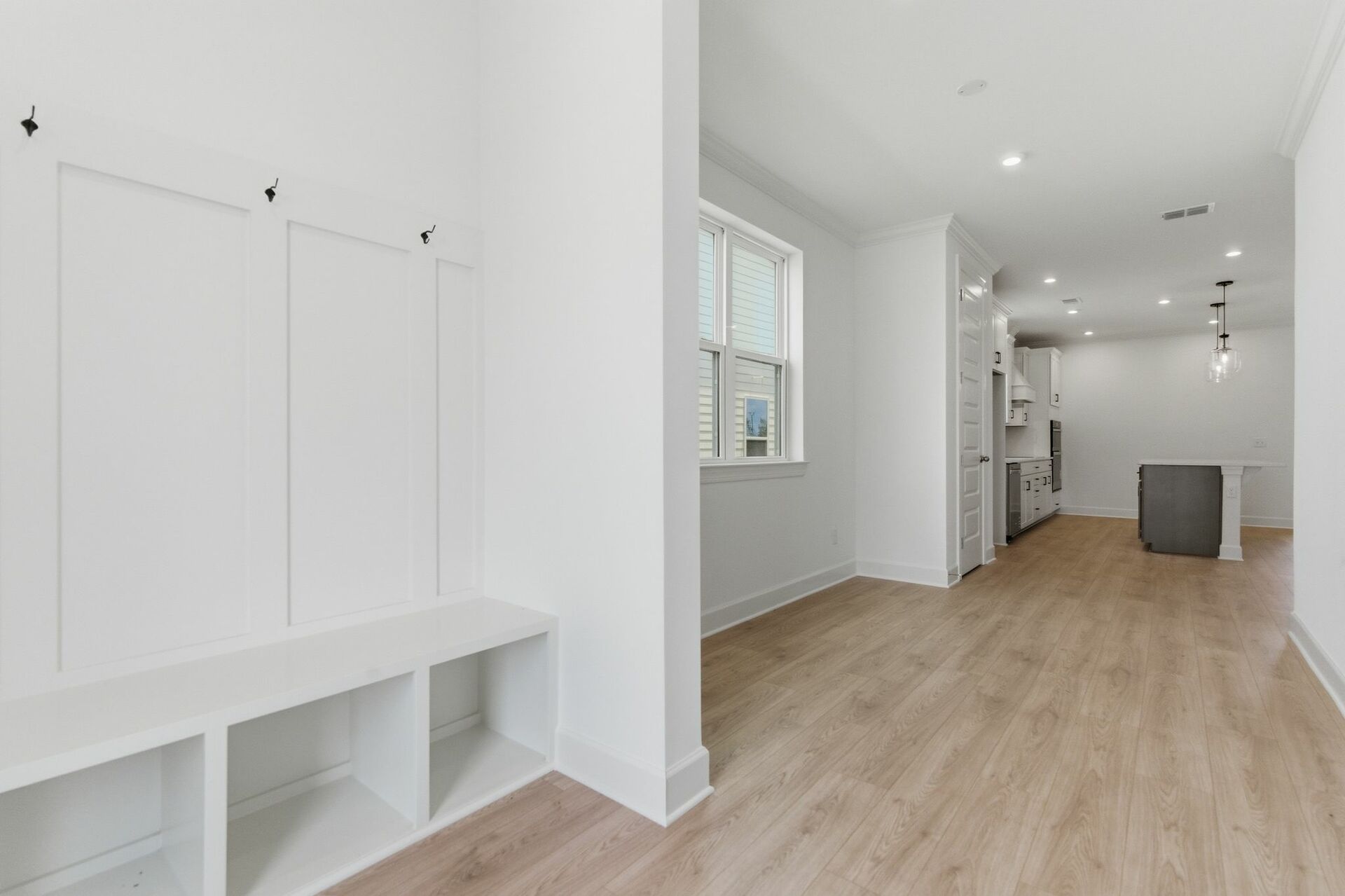 entryway with white valet bench with hooks for storage