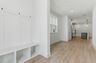 entryway with white valet bench with hooks for storage
