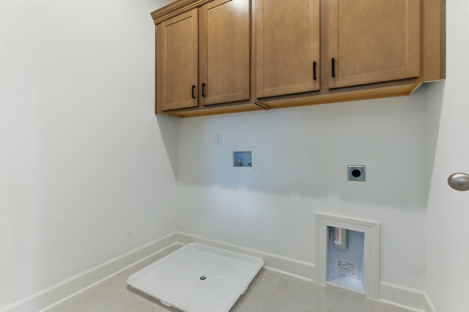 laundry room with overhead storage wooden shelves with matte black hardware