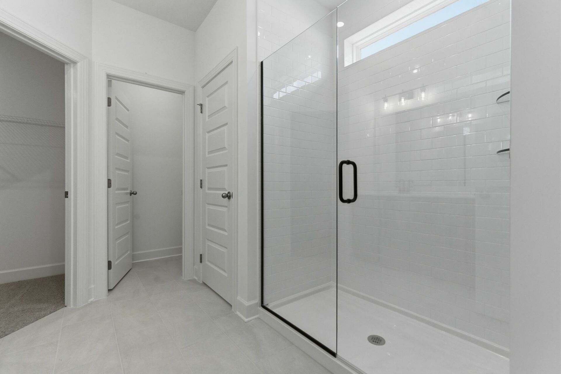 primary bathroom with wood cabinets, dual sink vanity with matte black hardware, and an oversized walk-in shower