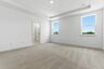 primary bedroom with carpet, large windows, tray ceiling, and large walk-in closet