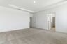 primary bedroom with carpet, large windows, tray ceiling, and large walk-in closet