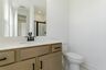 bathroom with wood cabinets and matte black hardware