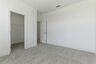 secondary bedroom with carpet, large windows, and walk-in closet