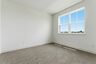 secondary bedroom with carpet, large windows, and walk-in closet