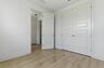 bedroom with light wood floors large windows, and a double door closet