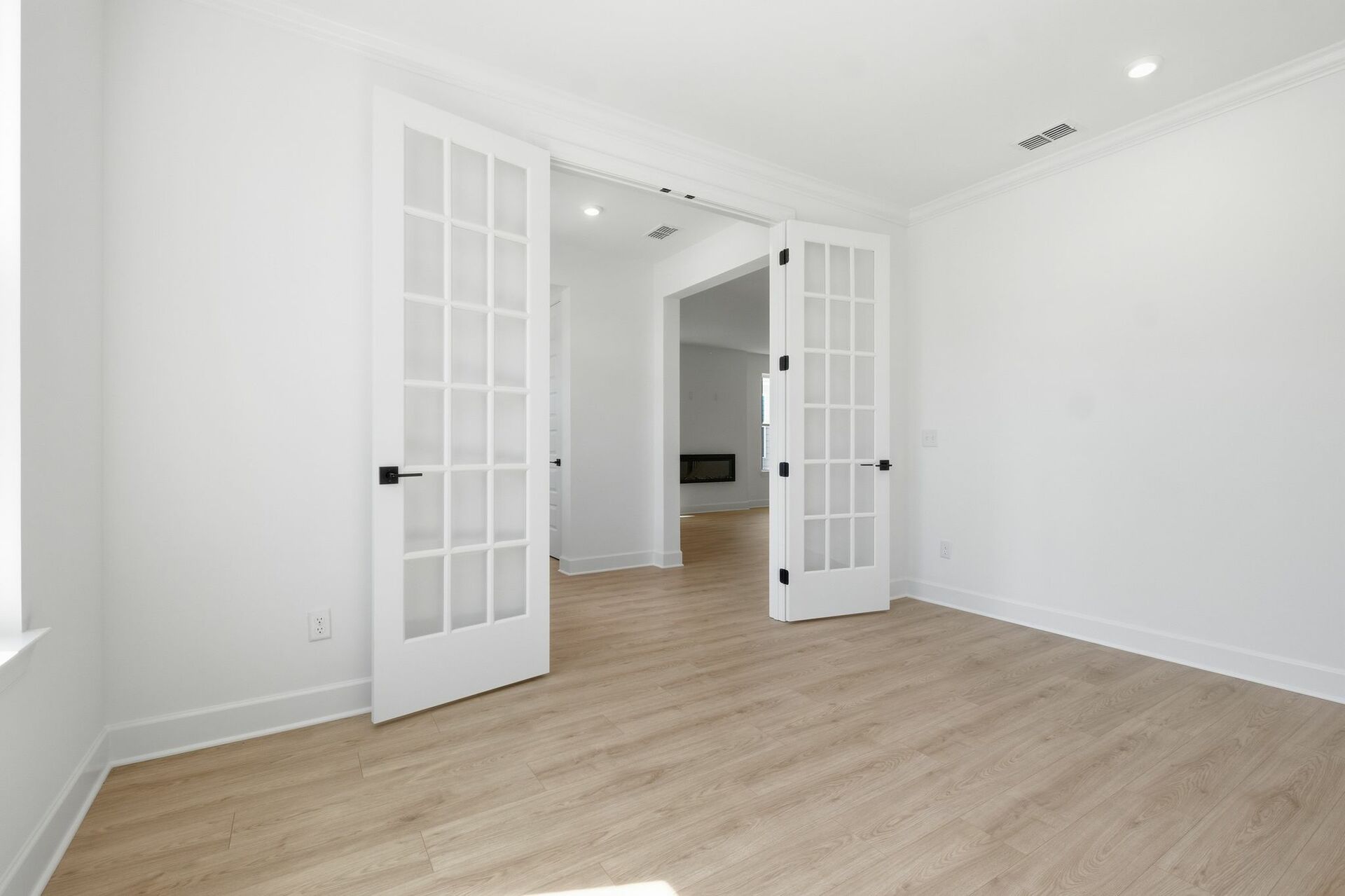 study with wood floors, large windows, and french doors