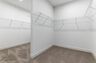 walk in closet with carpet, built-in shelving, and a half-wall divider