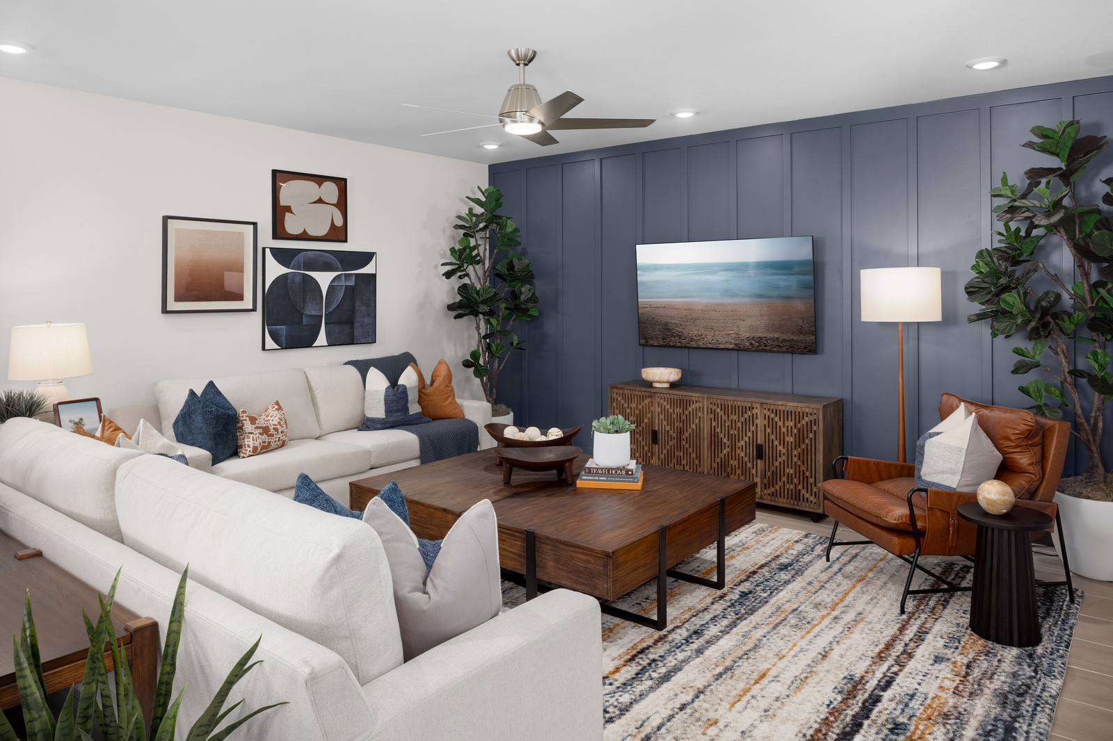 great room with blue accent wall and white sofas