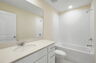 single sink vanity with mirror, water closet and tub