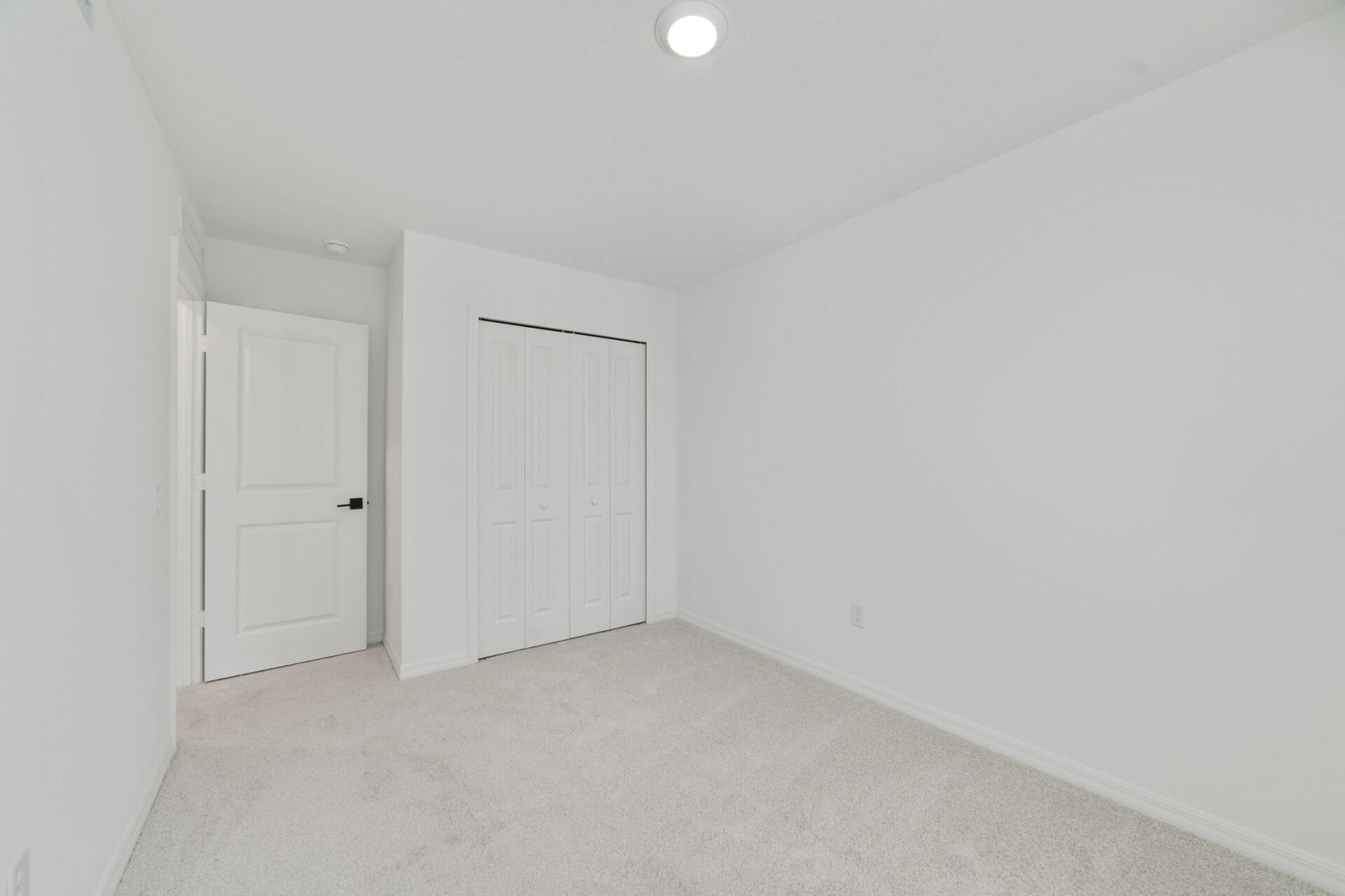 room with carpet throughout and large single window and closet in the room 