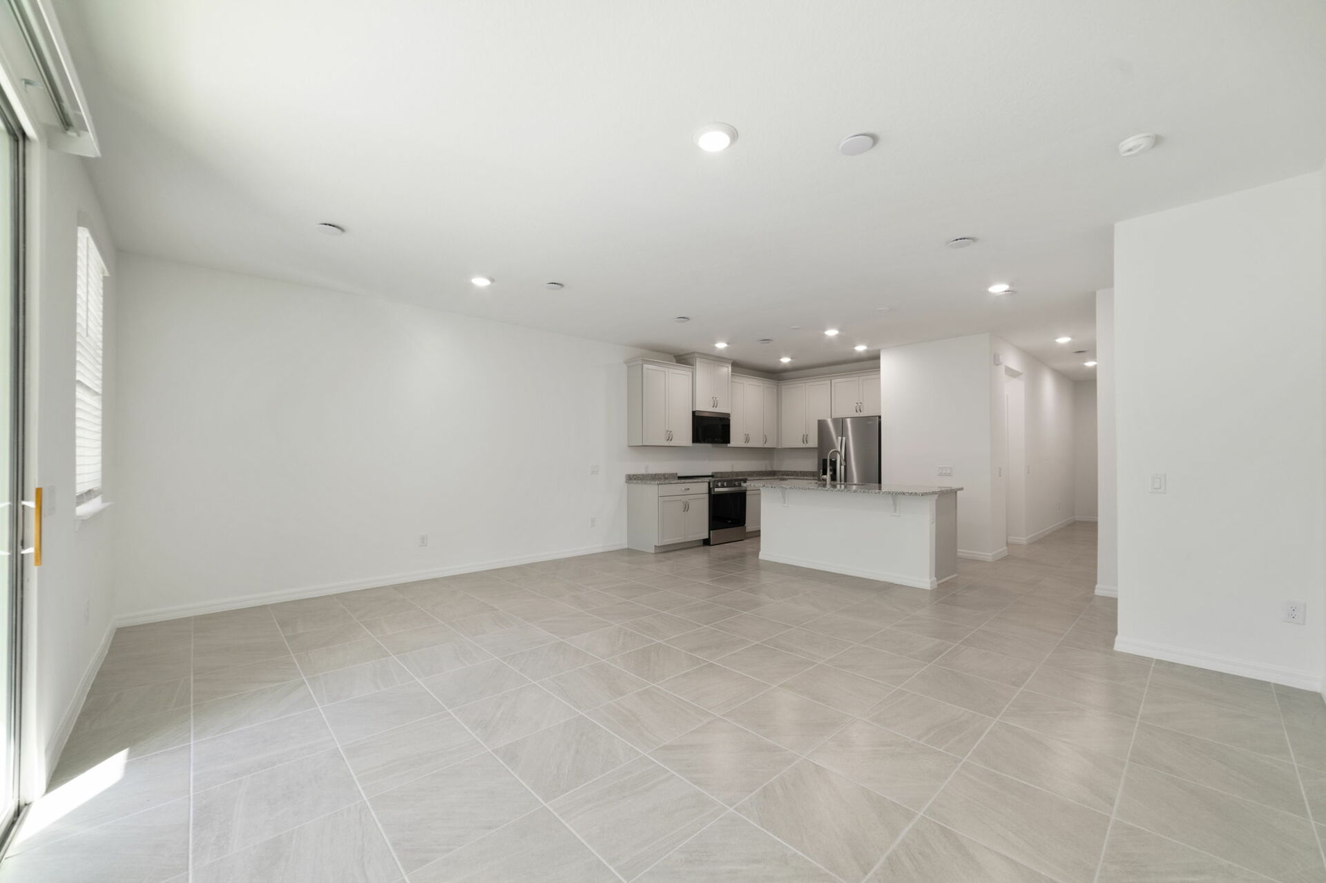 great room with access to the covered lanai and views of the kitchen