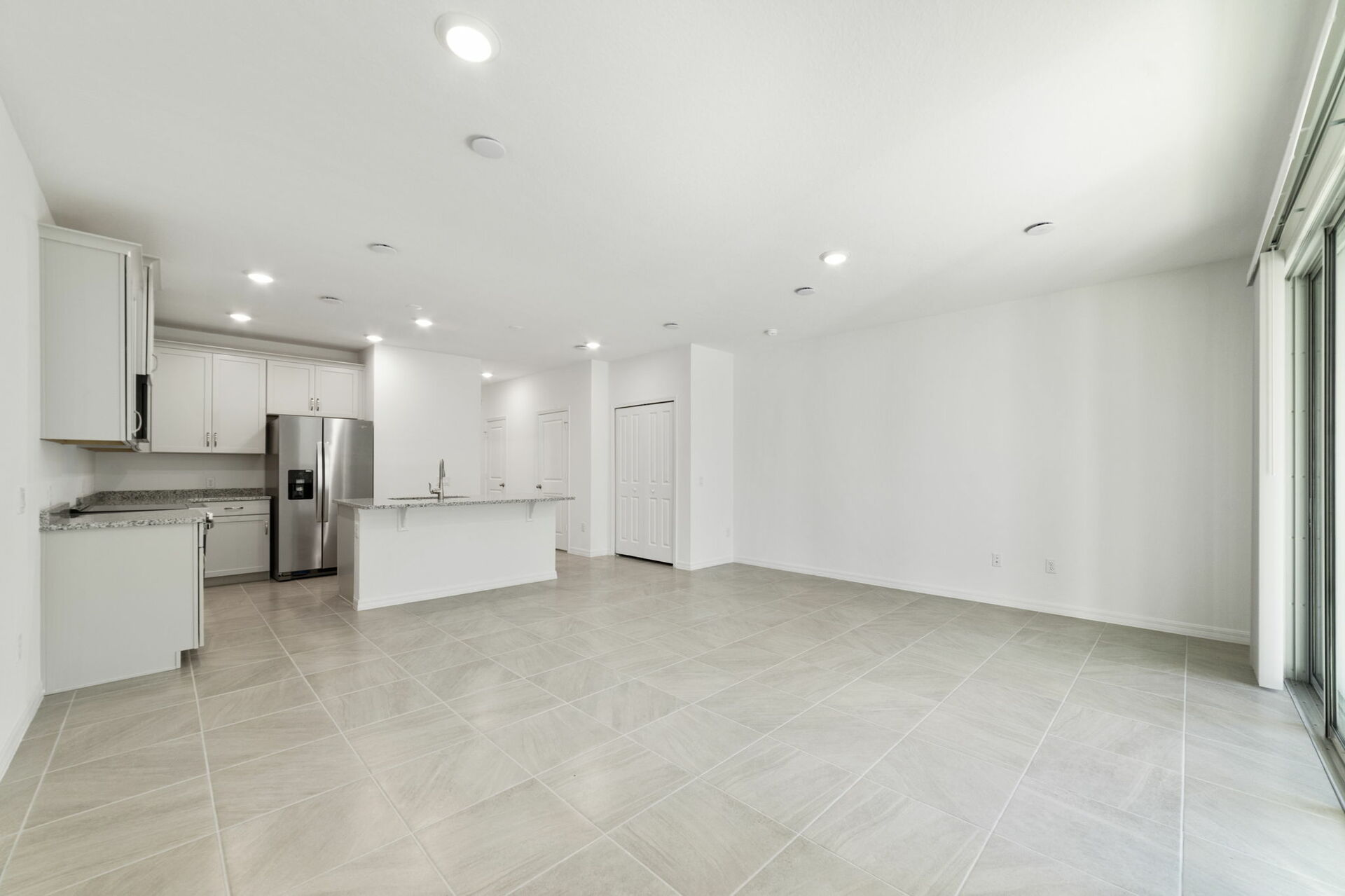 great room with access to the covered lanai and views of the kitchen
