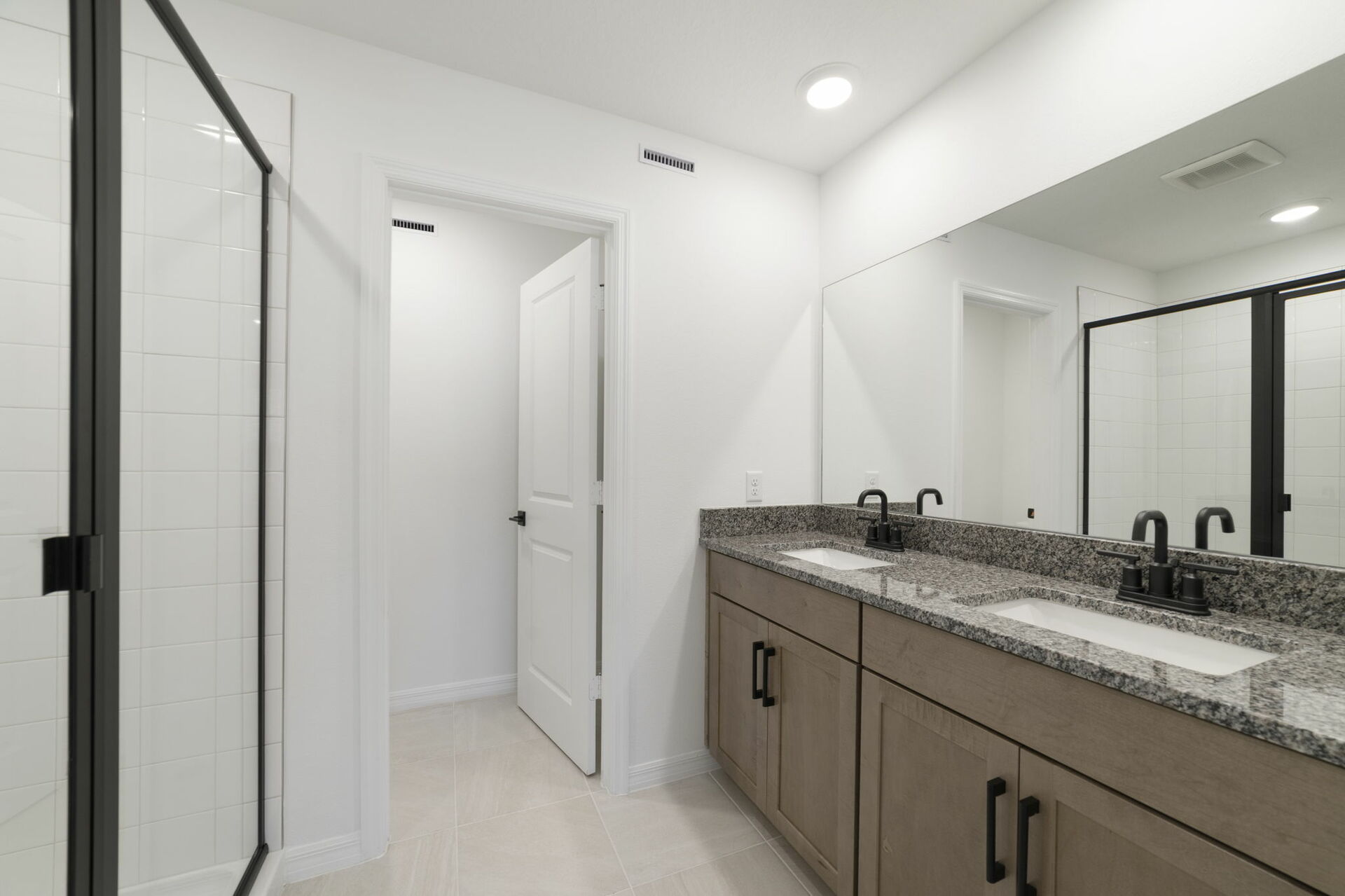 dual sink vanity with large mirror shower and water closet