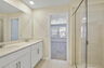 dual sink vanity with a large mirror and shower