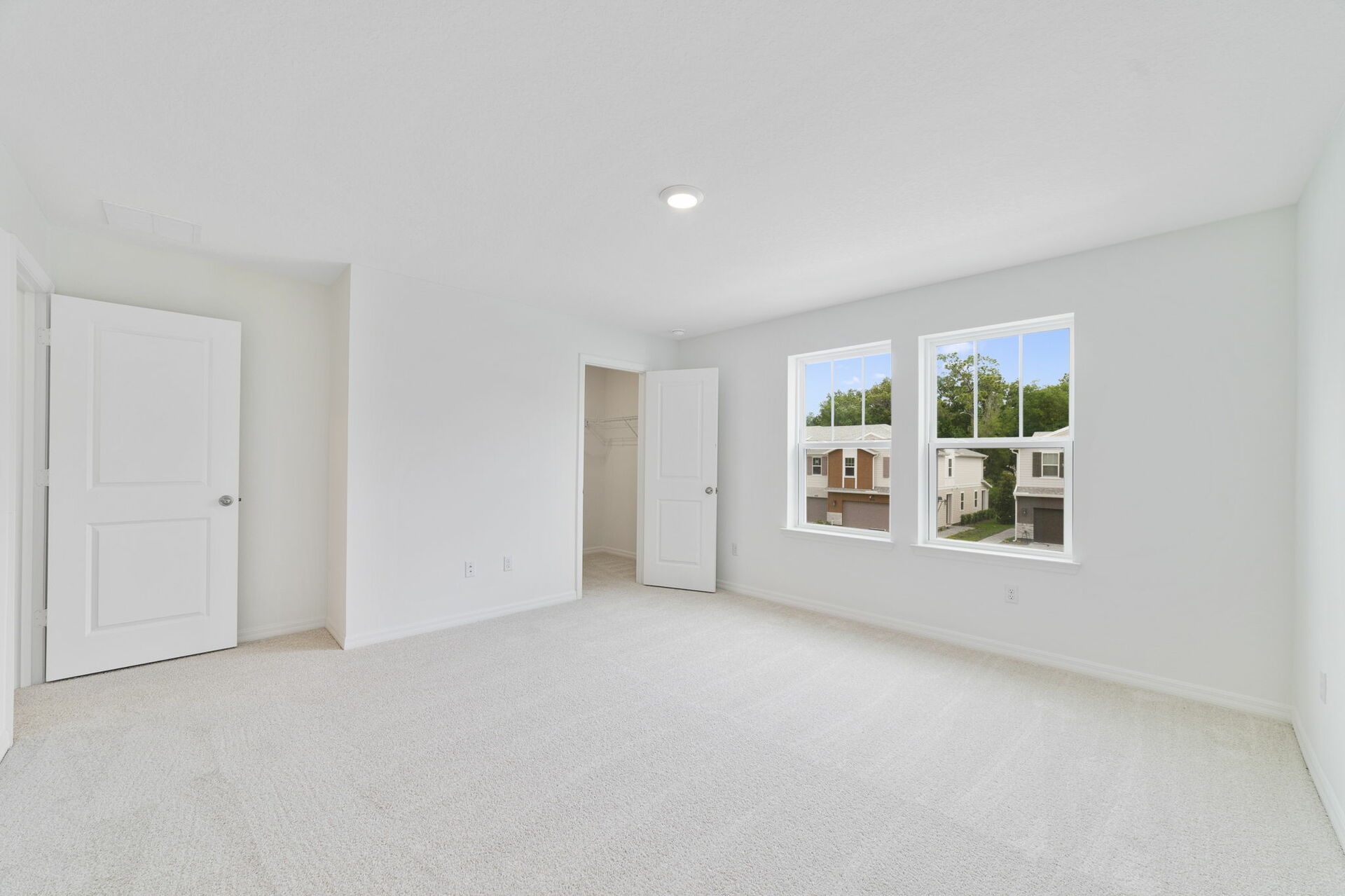 carpet throughout multiple windows and walk-in closet 
