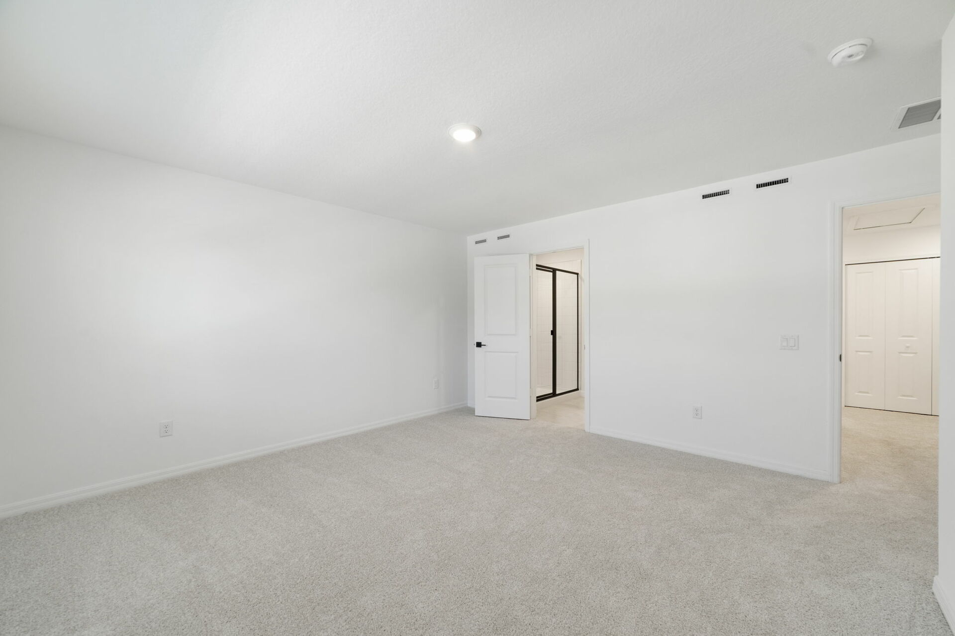 room with carpet throughout and access to primary bathroom and access to the loft