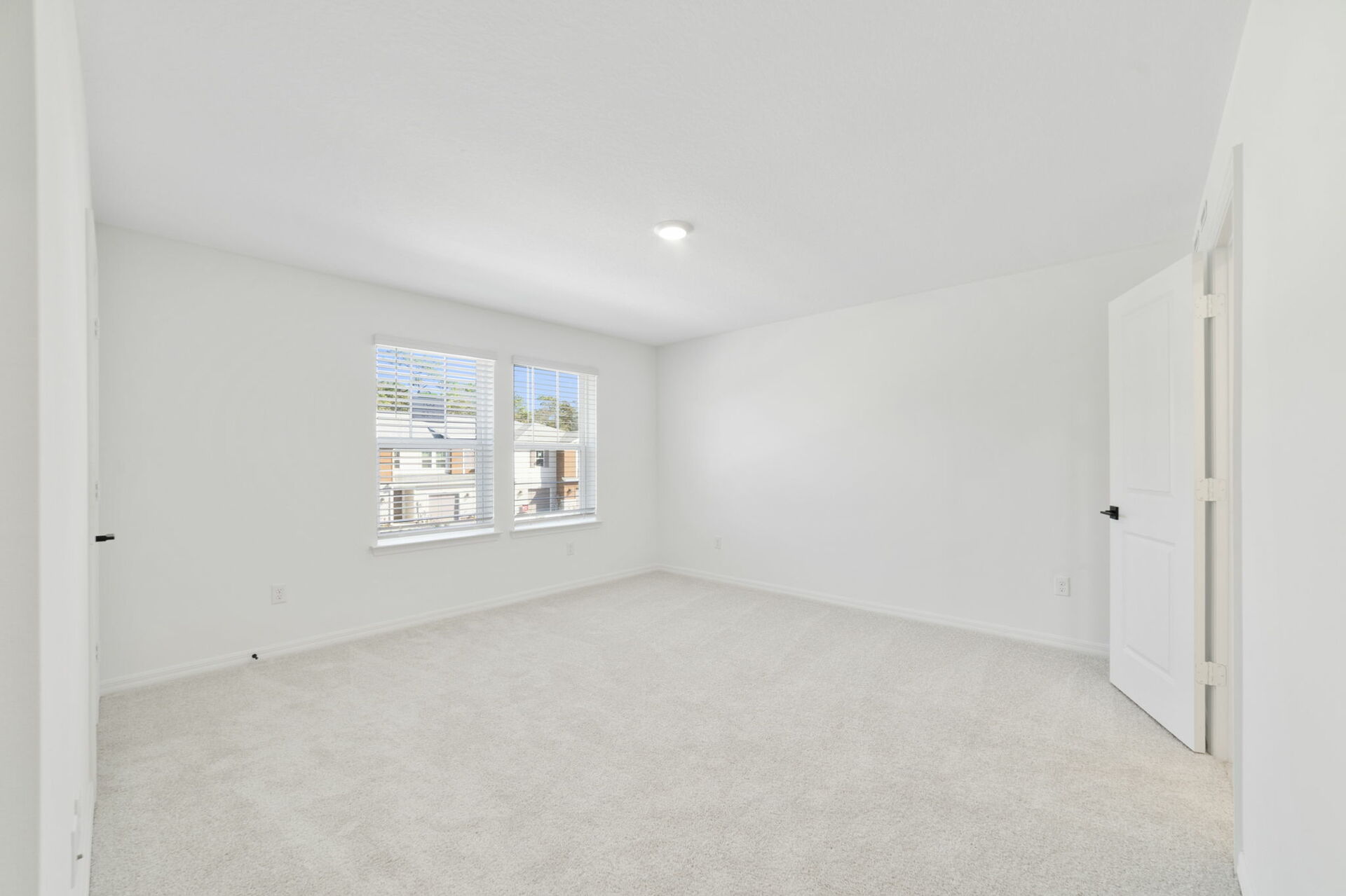 room with carpet throughout and access to primary bathroom and access to the loft