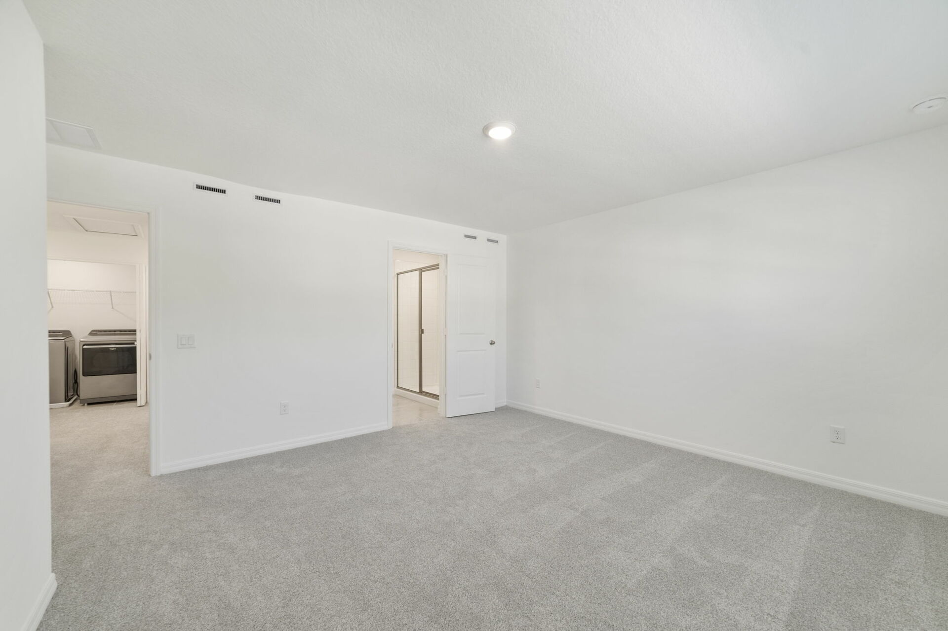 room with carpet throughout and access to the primary bathroom