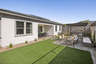 landscaped backyard with artificial grass, gazebo and concrete block wall 