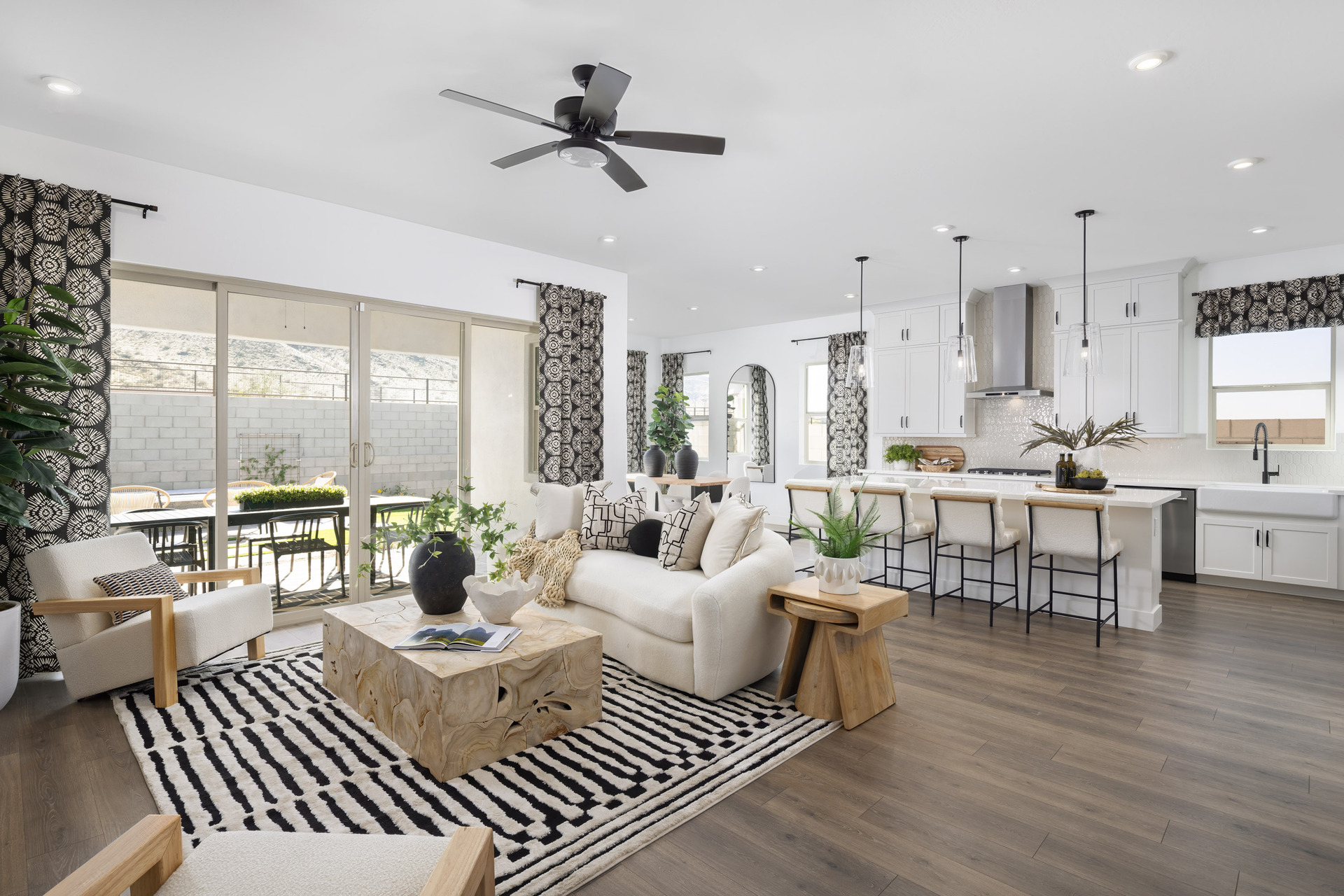 open-concept space with a large white couch, white accent chairs, and a wooden coffee table