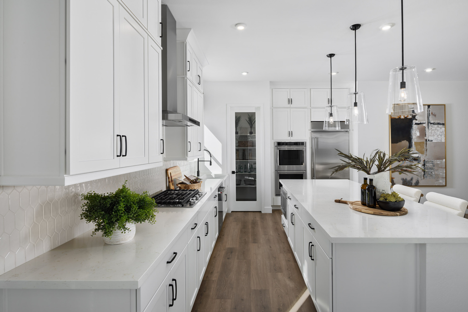 kitchen with white quartz countertops, black hardware on white cabinets, and stainless-steel appliances