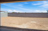 spacious dirt backyard with a concrete block wall 