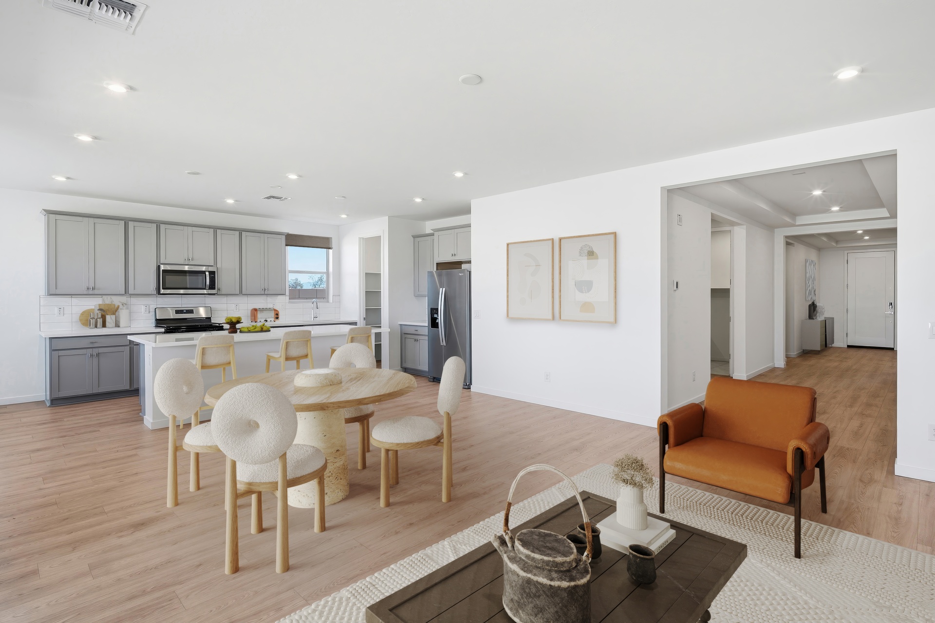 open-concept space with an oak dining table, white chairs, and orange accent chair
