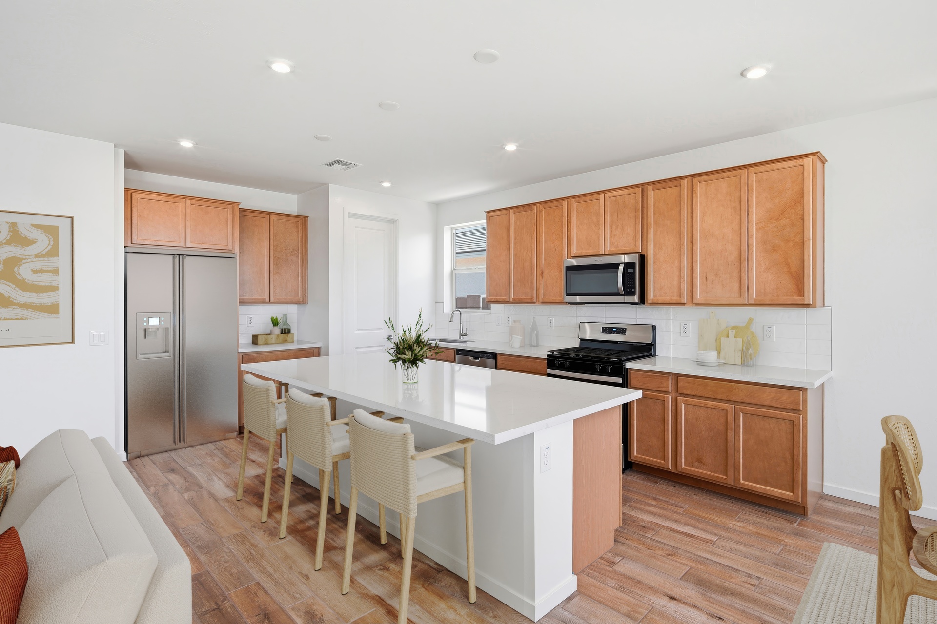spacious kitchen with quartz countertops, wooden barstools, and brown cabinets