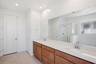 spacious bathroom with brown cabinets, white countertops, and chrome faucets
