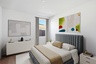 spacious room with a large neutral colored bed, a white dresser, and white nightstands
