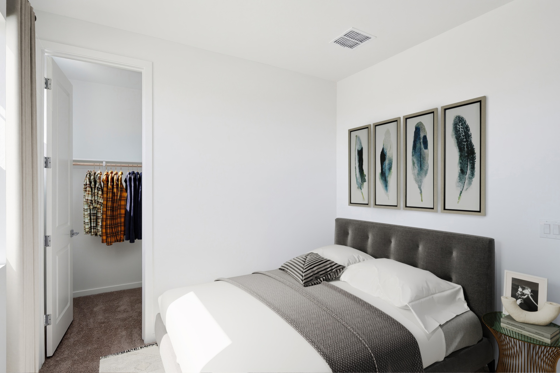 spacious bedroom with a bed, dark grey bedframe, and white rug