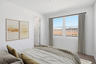 bedroom with a white rug, a large bed, and abstract art on the wall
