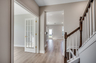 spacious hallway opening up to the study with french doors and the beautiful stairs with dark wood oak treads