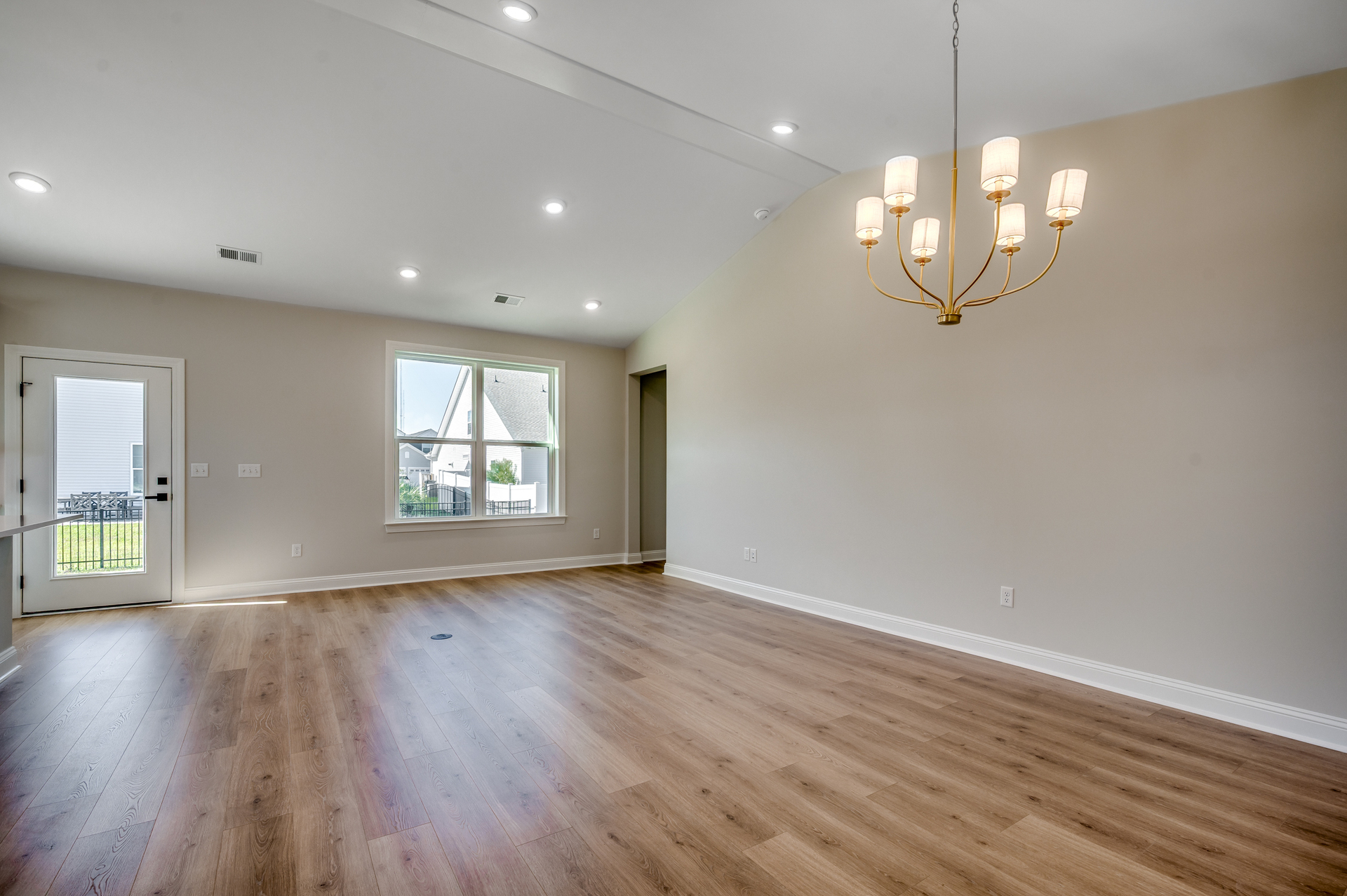 open-concept room with large windows for natural lighting and hardwood flooring throughout 