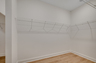 spacious walk-in closet with light gray walls and white wire built in shelving 