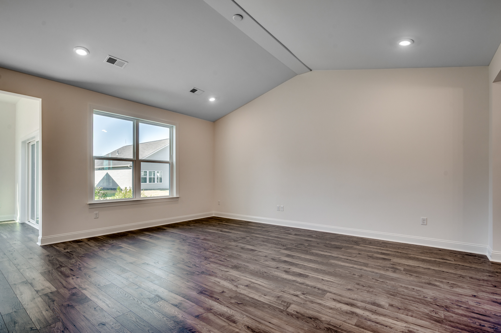 open-concept area with high ceilings, large windows for natural lighting and tan walls throughout