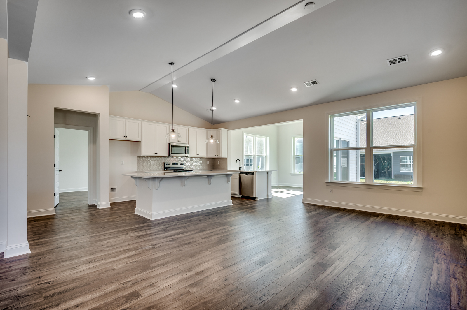 bright white kitchen with black pendant lighting and large island