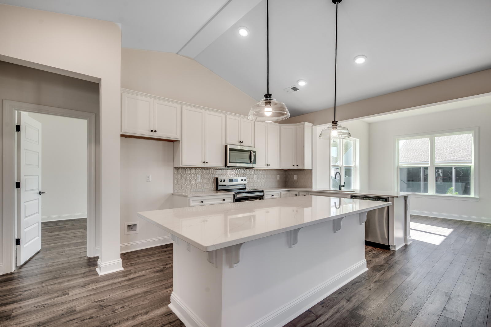 bright white kitchen with large island and black pendant lighting